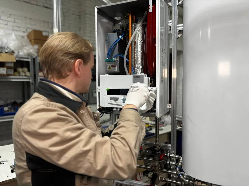 Heating engineer working on boiler components in a workshop